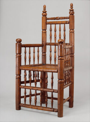 A spindle-back chair made of wood, very square in aspect.