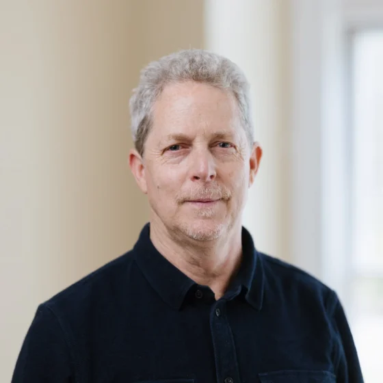A man in a black button up and a white hair