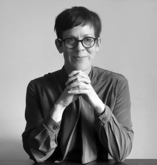 A black & white image of a woman with short hair and hands clapsed in front of her