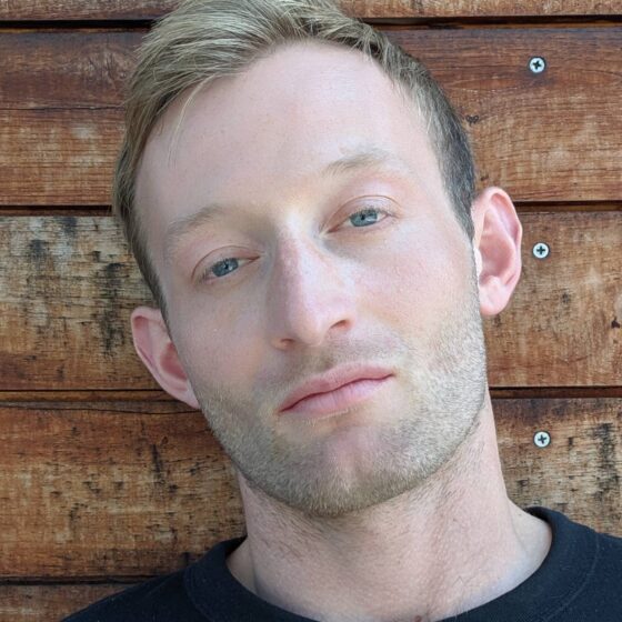 A blond man looking at the camera