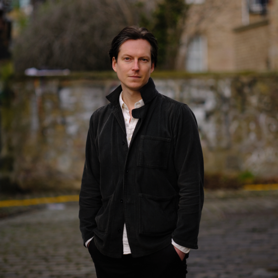A man in a coat with his hands in his pocket
