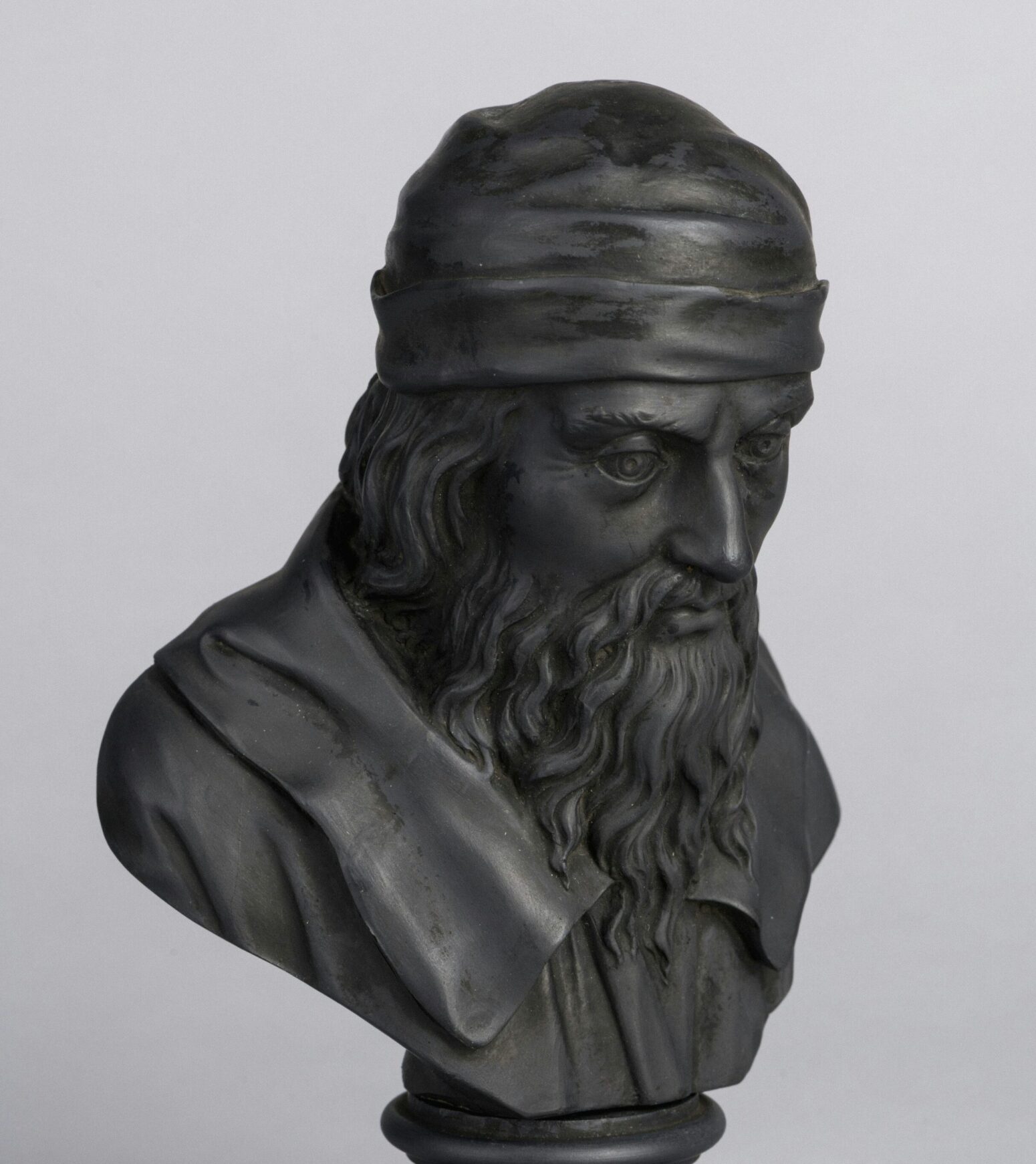 A dark bust of a bearded man