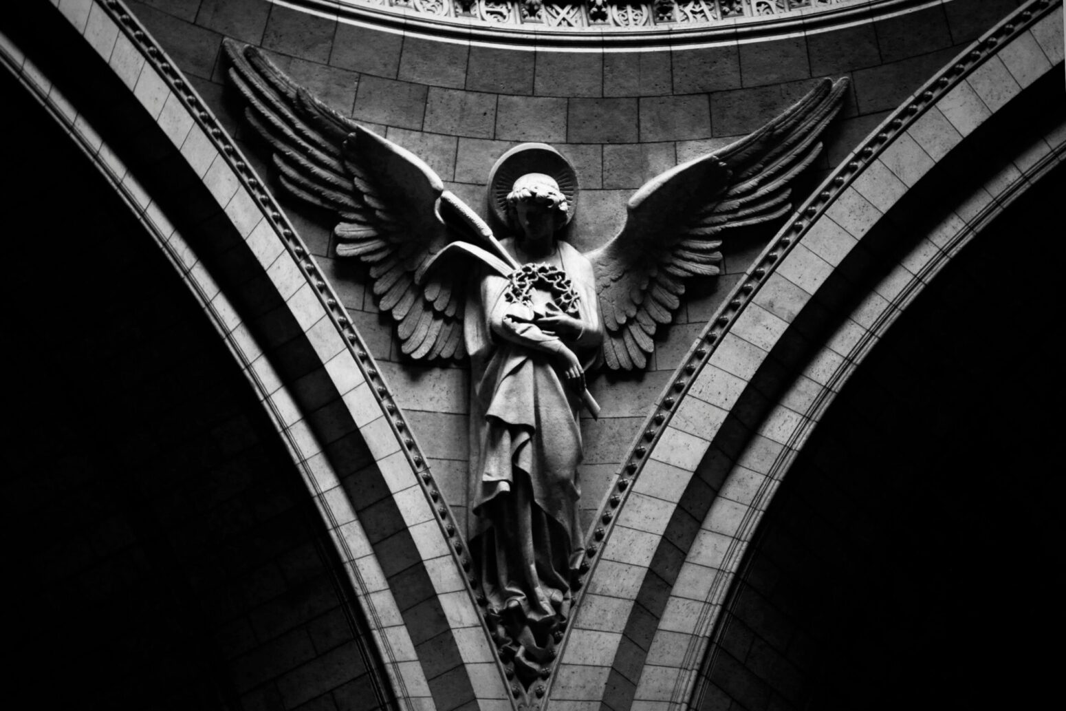 An stone statue of an angel mounted on a wall