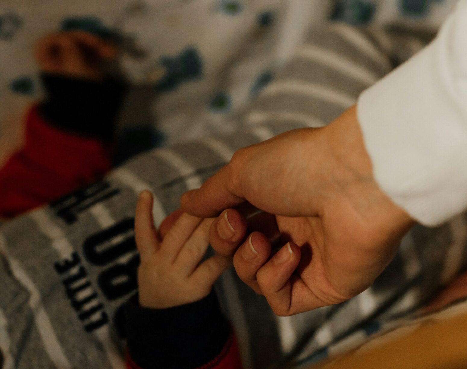 A father's hand holding baby's hand