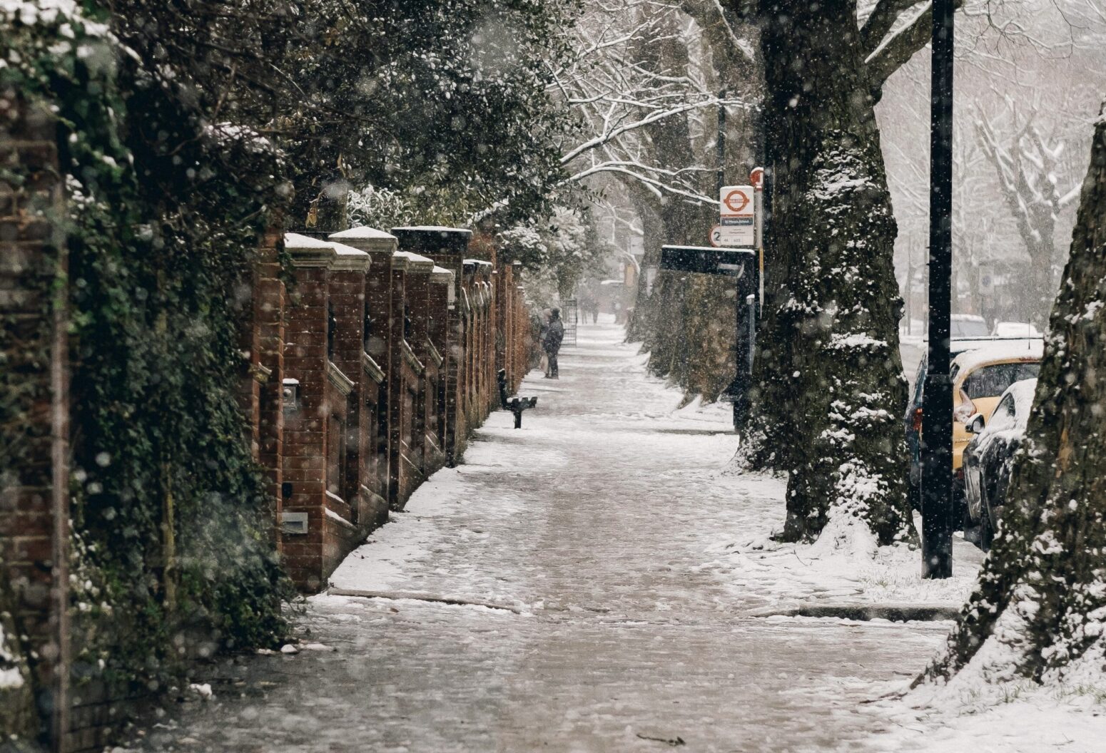 A sidewalk half covered in snow