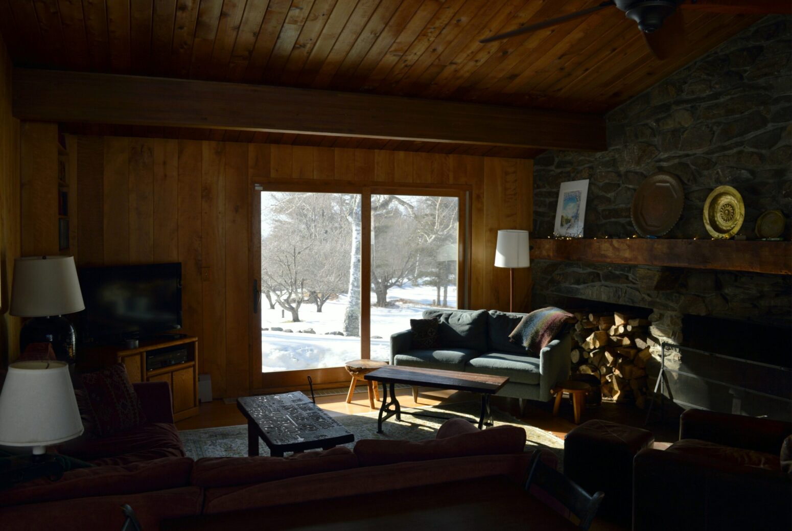 A dimly lit cabin room as it snows outside