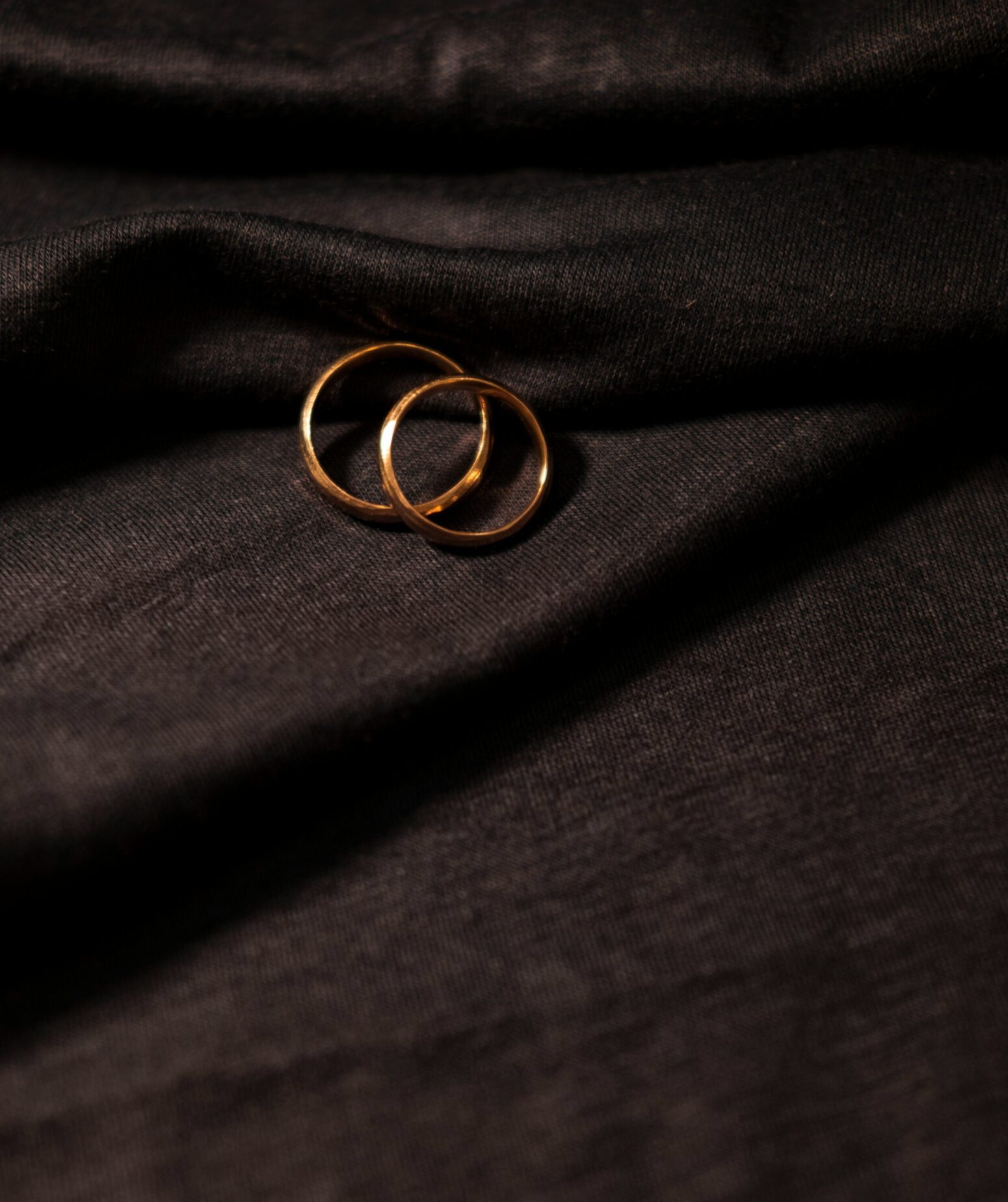 Two rings on top of one another on a dark sheet